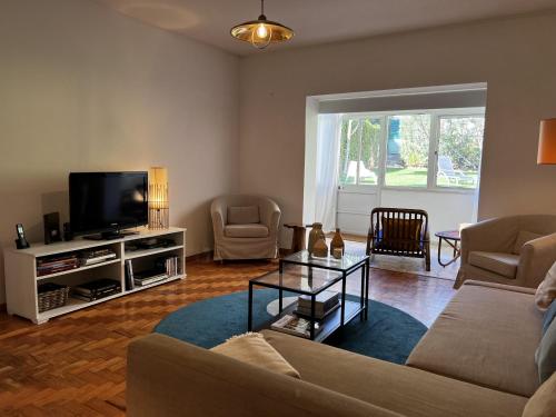 a living room with a couch and a tv at Cascais center House with garden in Cascais