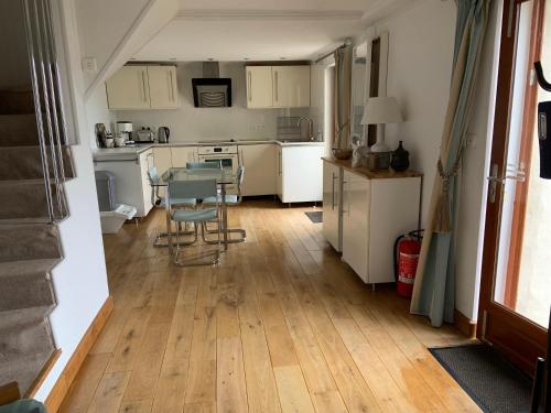 une cuisine avec des armoires blanches et une table et des chaises dans l'établissement Le Penty, à Landévennec