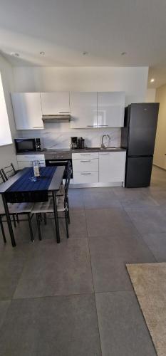 Il comprend une cuisine équipée d'une table et d'un réfrigérateur noir. dans l'établissement Beau Appartement T2, à Saint-Georges-dʼEspéranche