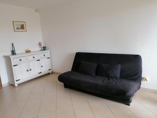 un sofá de cuero negro sentado en una sala de estar en Appartement Résidence Les Eucalyptus, en LʼÎle-Rousse