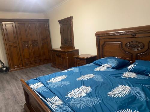 Schlafzimmer mit einem blauen Bett mit blauer und weißer Bettwäsche in der Unterkunft 3 Cosy apartment near Airport EVN in Yerevan