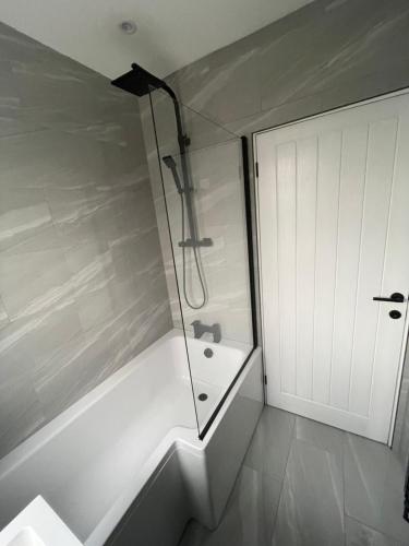 a bathroom with a shower and a bath tub at VA Home Stay in Luton