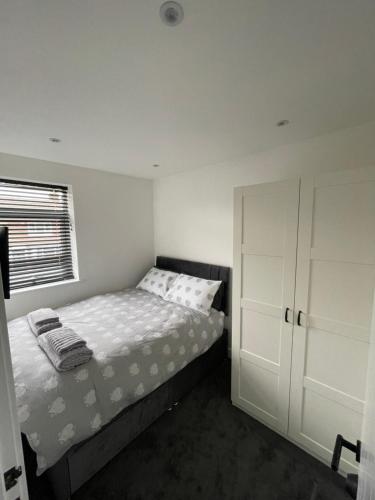 a white bedroom with a bed and a window at VA Home Stay in Luton