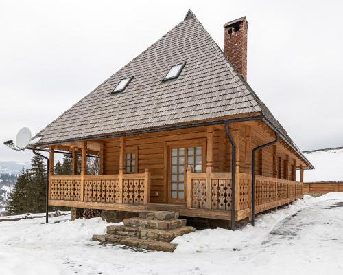 a log cabin with a porch in the snow at Апарт-Готель "Панщина" in Slavske