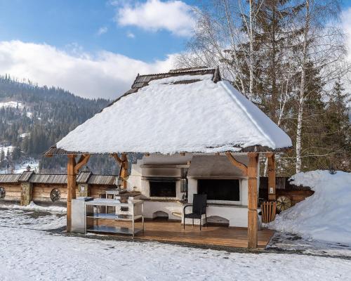 a gazebo with a snow covered roof in the snow at Апарт-Готель "Панщина" in Slavske