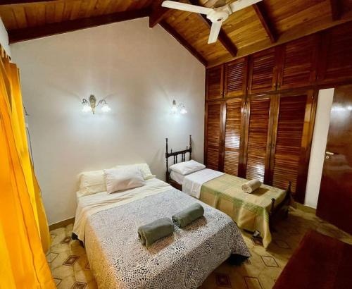 a bedroom with two beds and a ceiling at Moreno House in Corrientes