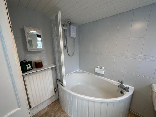 a white tub in a bathroom with a shower at Number 2 Seafield - sleeps 5 - Grantham town in Lincolnshire
