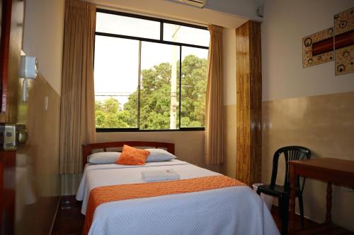 1 dormitorio con cama y ventana en Real Tarapoto, en Tarapoto