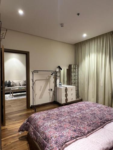 1 dormitorio con 1 cama grande y espejo en Luxury Apartment with Part Lake View, en Sharjah