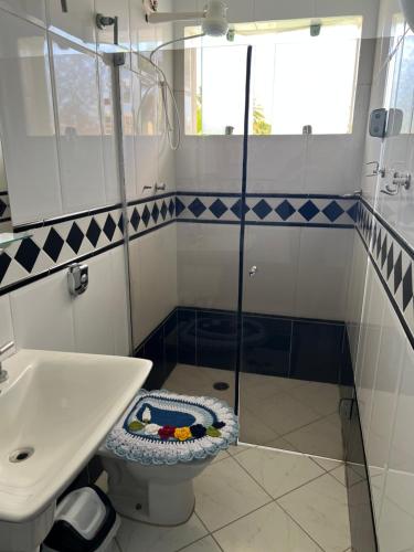 a bathroom with a shower and a toilet and a sink at Pousada Bellasophia in Guarujá