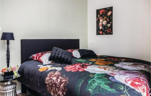 1 dormitorio con 1 cama con una manta colorida y una foto en Amazing Home In Ijzendijke With 3 Bedrooms And Wifi, en IJzendijke