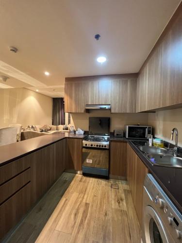 cocina con fregadero y fogones horno superior en Luxury Apartment with Part Lake View, en Sharjah