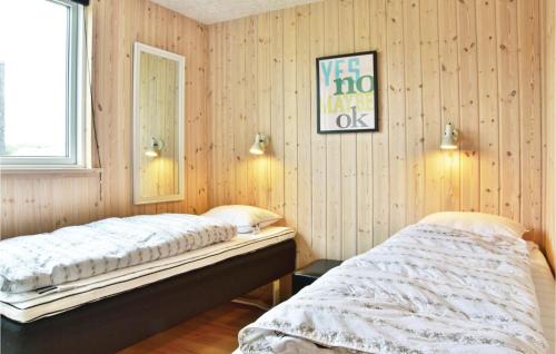 Habitación con 2 camas y paredes revestidas de madera. en Stunning Home In Ringkbing With Sauna, en Klegod