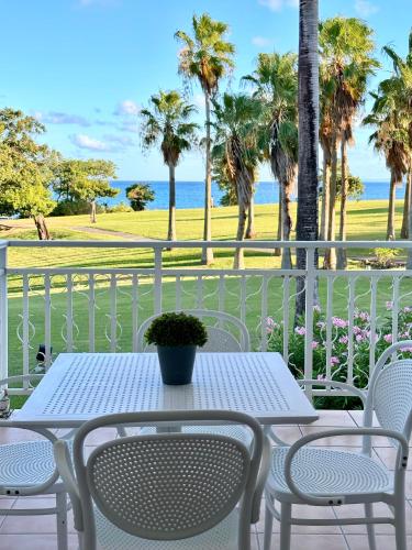 a table and chairs on a balcony with a view of the beach at Curaçao 13 studio vue mer proche plage dans Complexe type Village Vacances in Sainte-Luce