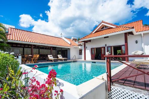 a villa with a swimming pool and a house at Bartholomew Villas in Saint Georgeʼs
