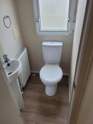 a small bathroom with a toilet and a sink at Seawick Holiday Park in Saint Osyth