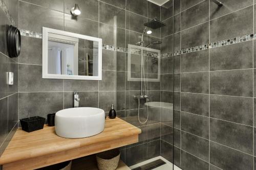 La salle de bains est pourvue d'un lavabo blanc et d'une douche. dans l'établissement Le Ti' Chajo Anse des Rochers vue mer, à Saint-François