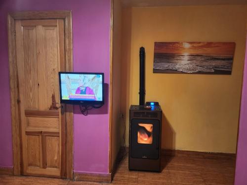 uma sala de estar com televisão e fogão em Vivienda de uso Turístico LARA 
