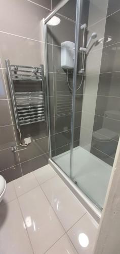 uma casa de banho com um chuveiro e uma porta de vidro em Leicester Central Apartments em Leicester