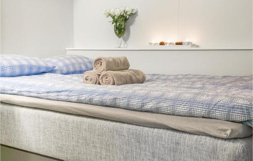 uma cama com toalhas e um vaso de flores em Beautiful Home In Leknes With 3 Bedrooms And Wifi em Kongsjorda