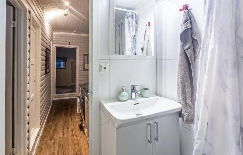 uma casa de banho branca com um lavatório e um espelho em Beautiful Home In Leknes With 3 Bedrooms And Wifi em Kongsjorda