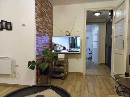 een woonkamer met een flatscreen-tv op een bakstenen muur bij Skyloft Zagreb in Zagreb