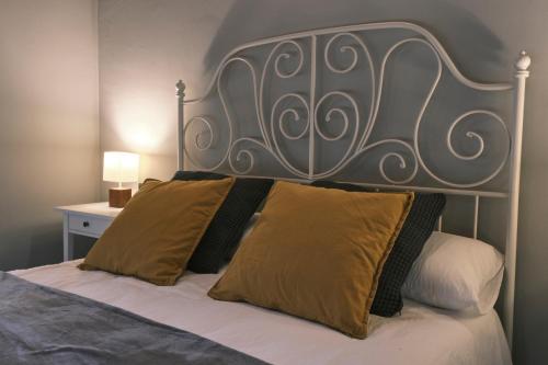 uma cama com cabeceira de metal e duas almofadas em Can Mateu, bonito apartamento céntrico con parking em Camprodon