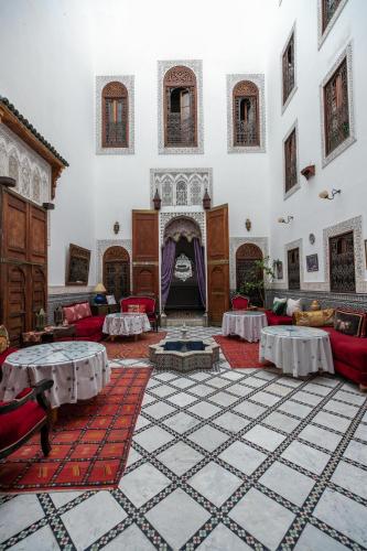 a large room with couches and a fireplace at Riad Arabella in Fès