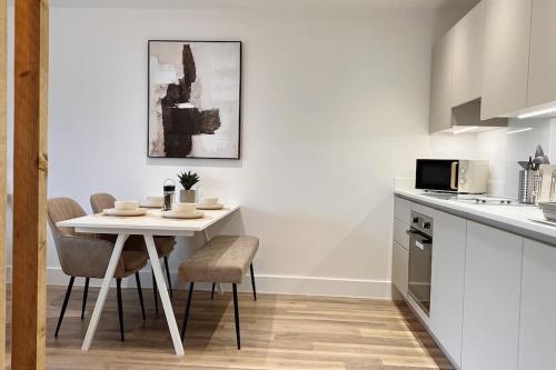 a kitchen with a table and chairs in a kitchen at No29, Luxury Apartment near Bicester Village in Bicester