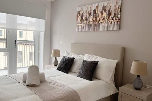um quarto com uma grande cama branca e 2 candeeiros em No29, Luxury Apartment near Bicester Village em Bicester