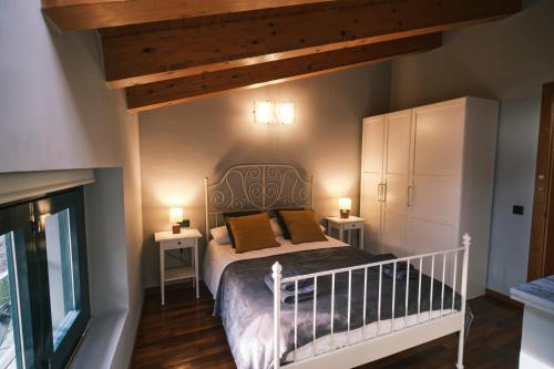 um quarto com uma cama com duas mesas de cabeceira e dois candeeiros em Can Mateu, bonito apartamento céntrico con parking em Camprodon