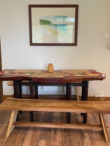 a wooden table with a bench in a room at Charming Country Cottage just a few steps from the beach! in Waianae