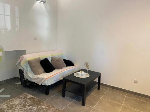 uma sala de estar com um sofá e uma mesa em Studio au centre du village em Châteauneuf