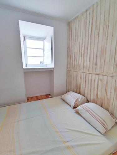 a bed in a room with a window and a window at Small lovely studio in Lisbon