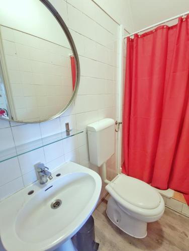 a bathroom with a sink and a toilet and a mirror at Small lovely studio in Lisbon