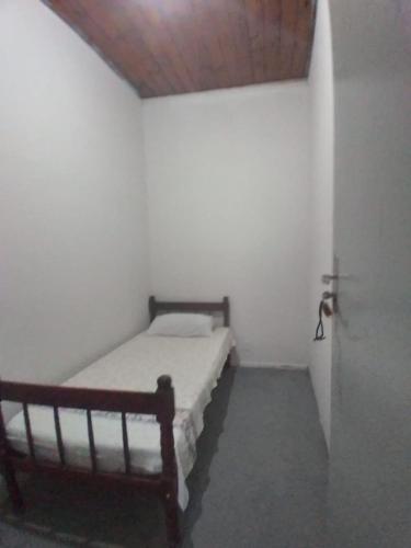 a bed in a room with a wooden ceiling at Hostel Gomes in São Paulo