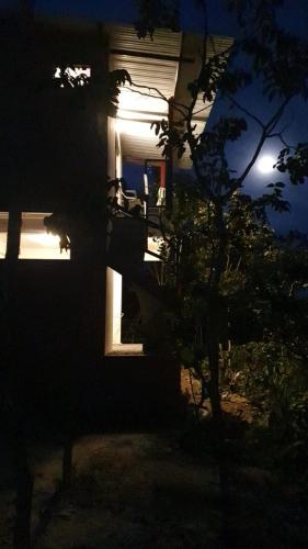 a house at night with the moon in the background at Chales Estrela Veadeiros in Alto Paraíso de Goiás