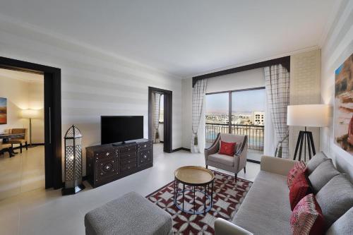a living room with a couch and a tv at Al Manara, a Luxury Collection Hotel, Aqaba in Aqaba