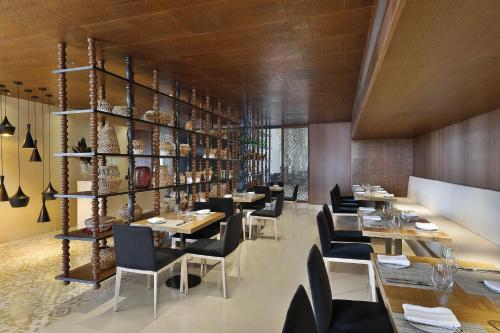 a restaurant with tables and chairs and a shelf with vases at Al Manara, a Luxury Collection Hotel, Aqaba in Aqaba
