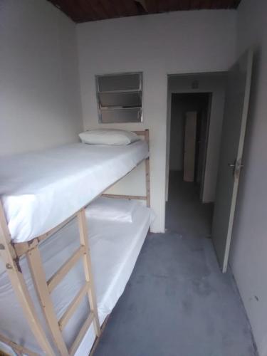 Våningssäng eller våningssängar i ett rum på Hostel Gomes