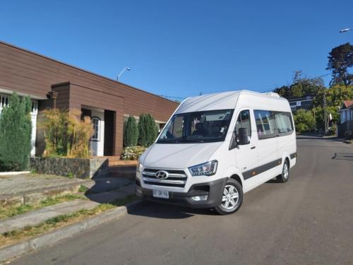 a white van parked in front of a house at Hotel Bután Coronel in Coronel