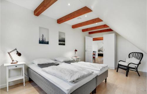 ein Schlafzimmer mit einem großen Bett und einem Stuhl in der Unterkunft Nice Home In Grindsted With House A Panoramic View in Grindsted