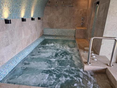 a jacuzzi tub in a bathroom with a shower at Espectacular casa de montaña con jacuzzi, chimenea a leña y BBQ in Zarcero