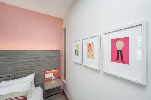 a bedroom with four pictures on the wall at The Julia Hotel in Miami Beach