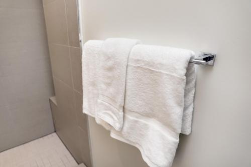 a white towel hanging on a towel rack in a bathroom at The Julia Hotel in Miami Beach