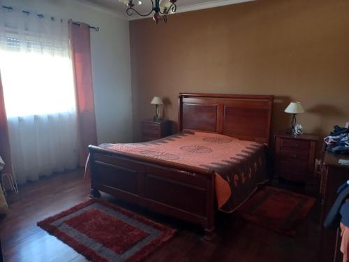 1 dormitorio con cama de madera y ventana en Casa da Avó Judite, en Óbidos