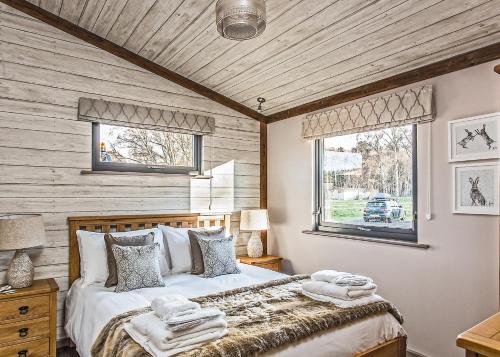 ein Schlafzimmer mit einem großen Bett und einer Holzdecke in der Unterkunft The Sherwood Hideaway Lodges 