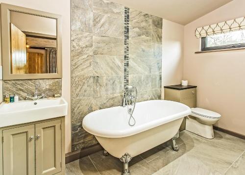 a bathroom with a tub and a toilet and a sink at The Sherwood Hideaway Lodges 