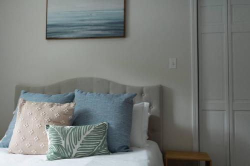 a bed with pillows and a picture on the wall at Relaxing 5-Bedroom Villa with Outdoor Oasis in Bay Saint Louis