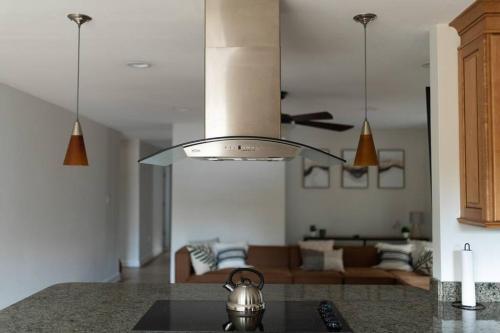 a kitchen with a ceiling fan and a living room at Relaxing 5-Bedroom Villa with Outdoor Oasis in Bay Saint Louis